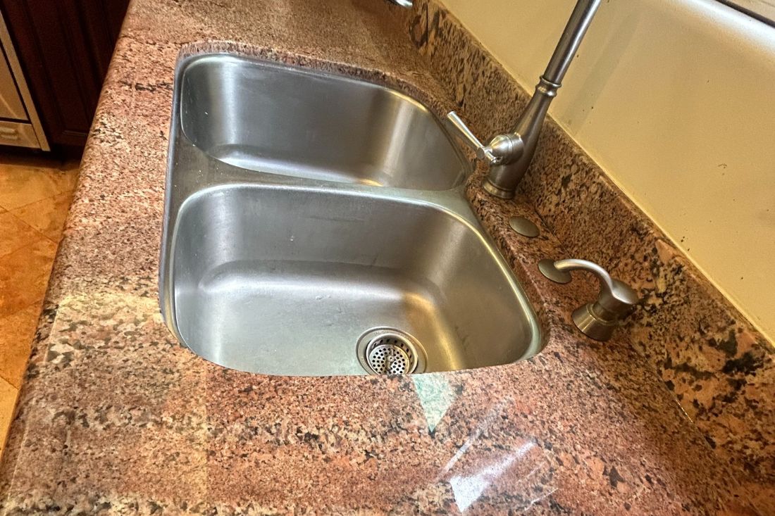 Restored granite countertop after StoneShine's crack repair service in Los Angeles. The once-damaged area near the sink is now seamlessly repaired, with a smooth, polished, and uniform surface.