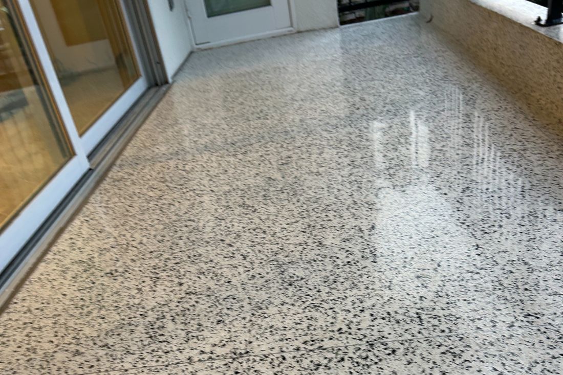 Finished look of StoneShine's terrazzo floor refinishing for a commercial space in Laguna Beach. The surface now has a sleek, polished appearance with clear reflections and a revitalized finish.