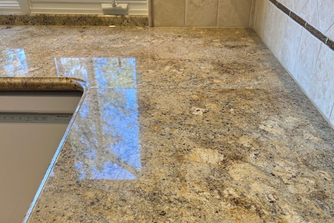 StoneShine's granite countertop polishing service in Huntington Beach. The once-muted kitchen surface now gleams with a smooth, mirror-like finish, adding depth and luxury to the space.