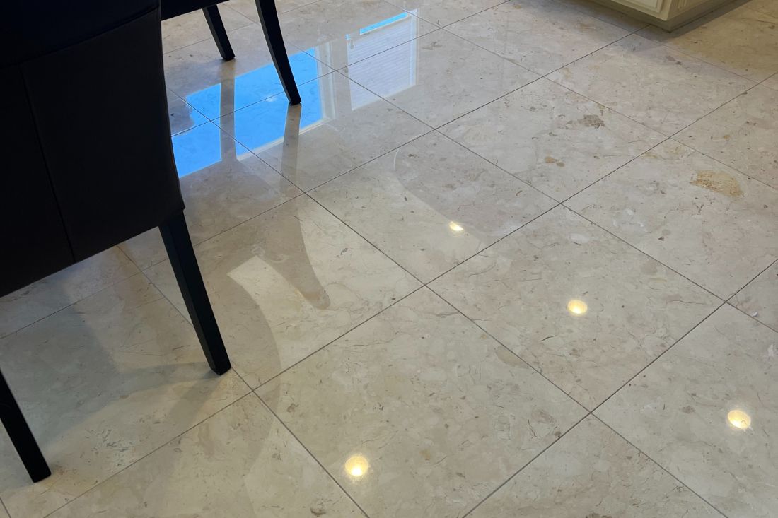 After StoneShine's marble polishing service in Los Angeles. A kitchen floor now features a high-gloss, reflective marble finish with enhanced clarity and elegance.