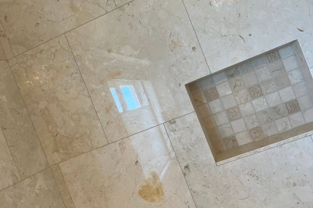 Polished marble wall surface in a Los Angeles home restored by StoneShine. The refinished stone showcases a clean, reflective sheen with detailed tile inlay for a refined look.