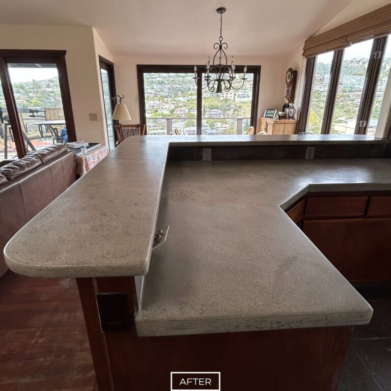 Smooth concrete countertop after grinding in Laguna Beach kitchen with oceanview windows.