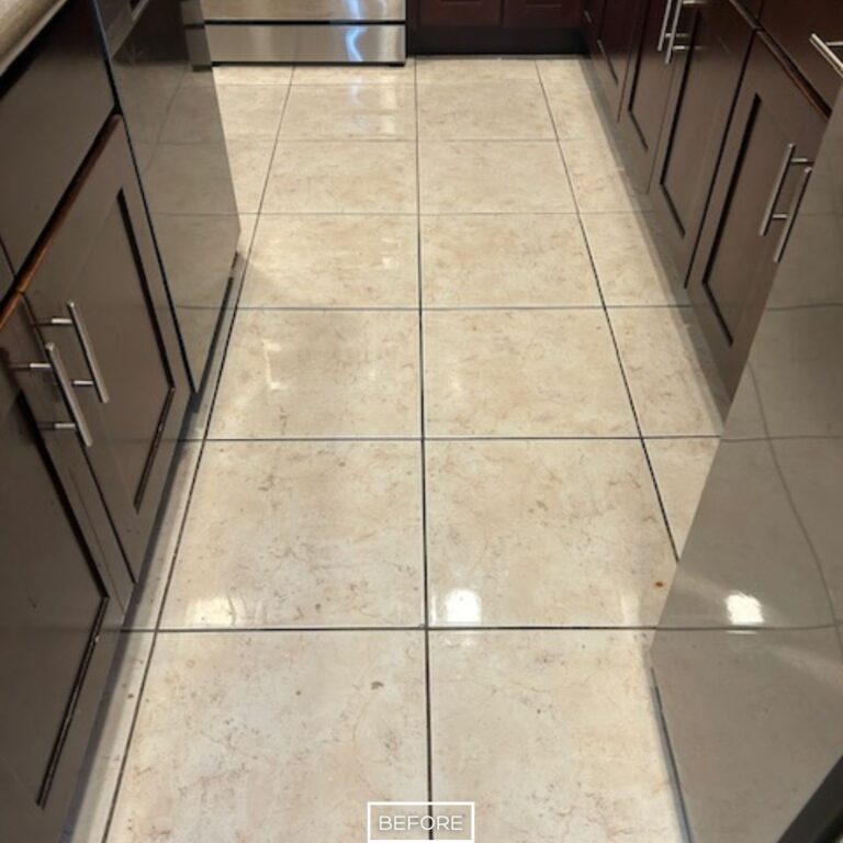 Etched marble floor with surface buildup in kitchen before restoration in Orange
