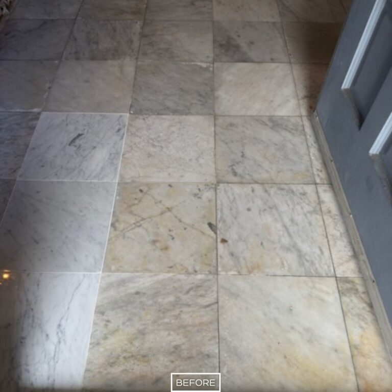 Worn and stained marble flooring near entrance before restoration in Seal Beach