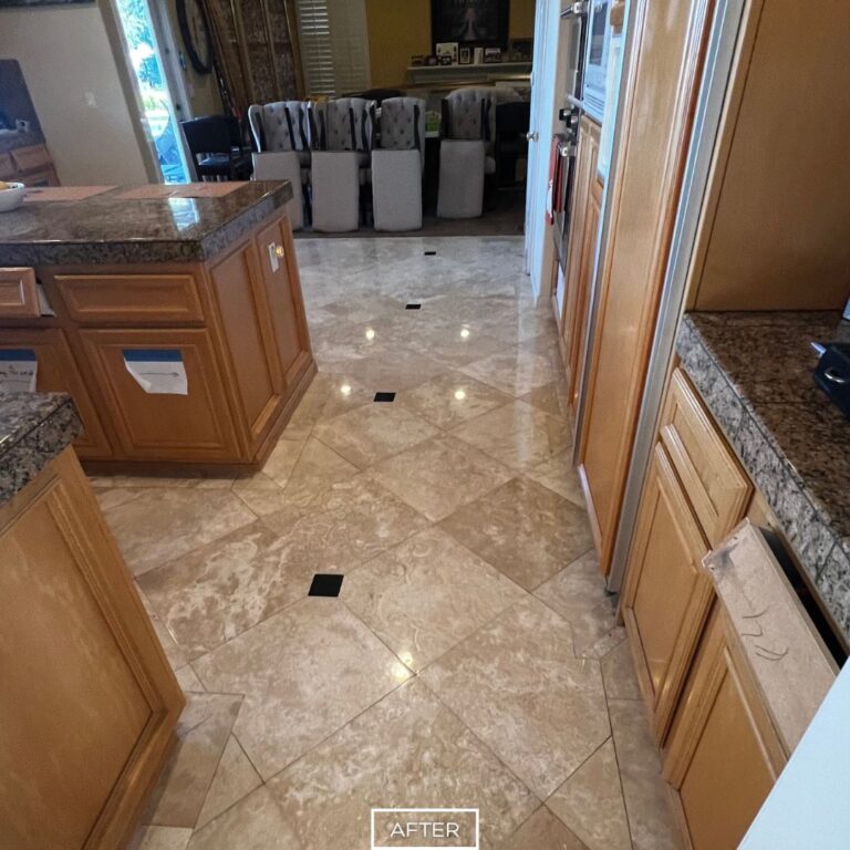 Refinished travertine floor in Chino Hills kitchen after restoration, delivering a smooth reflective surface along the walkway.