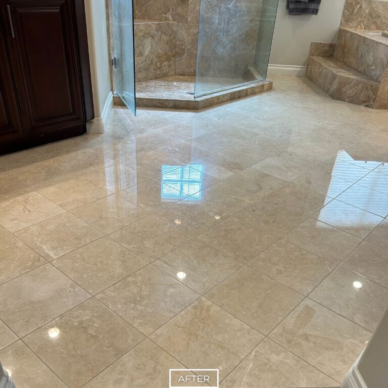 Polished travertine bathroom floor in Indian Wells after restoration, showing smooth reflective tiles near the shower and stone tub.