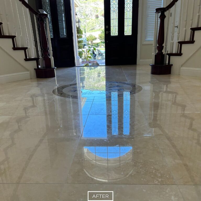 Newport Beach staircase entry with fully restored travertine flooring and medallion centerpiece