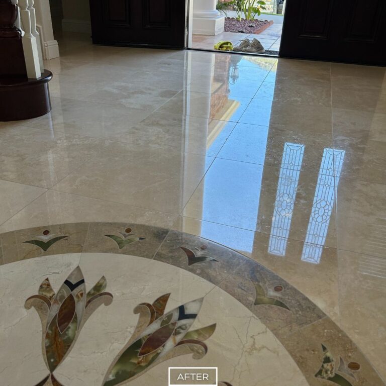 Polished travertine entryway with detailed medallion and clear outdoor reflection in Newport Beach