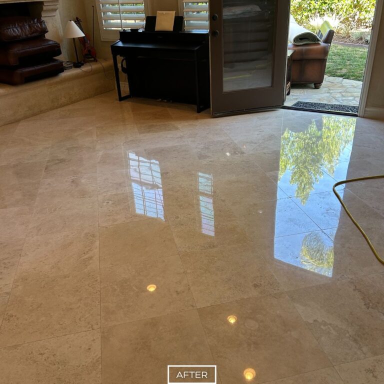 Restored travertine floor in San Clemente living area with high gloss finish, reflecting windows and natural light.
