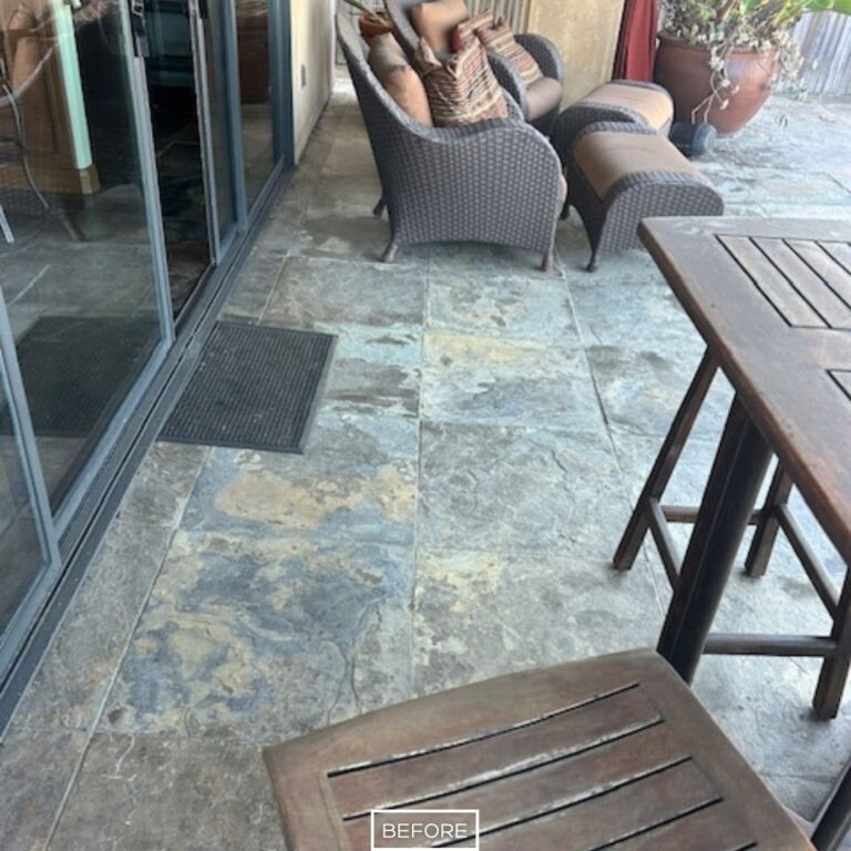 Outdoor slate floor in Seal Beach before restoration, with faded tiles and dull appearance near sliding glass doors.