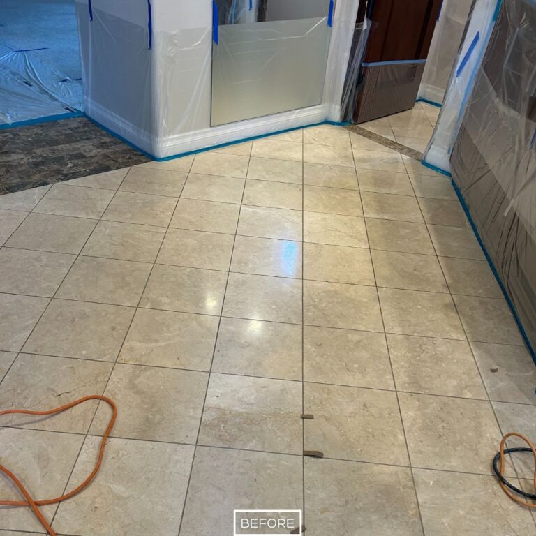 Stained travertine tile floor in Indian Wells residence before restoration, showing surface dullness and dirt buildup under protective coverings.