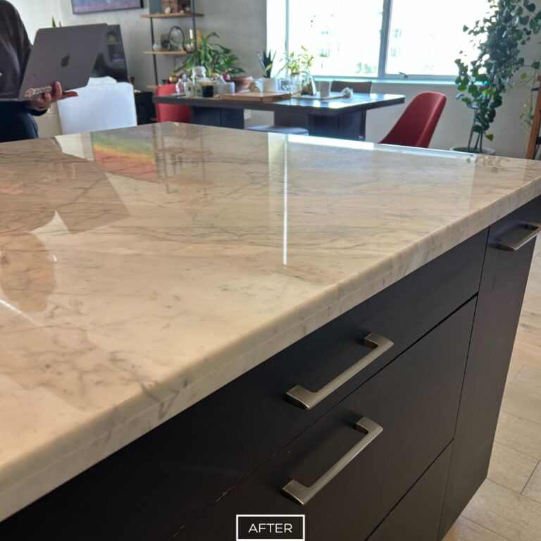 Restored marble kitchen island with a polished, reflective finish that highlights the stone’s natural veining.