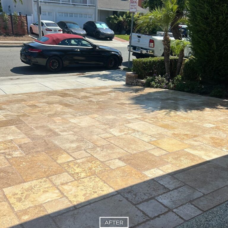 Restored travertine driveway in Huntington Beach with even tones and renewed stone appearance.