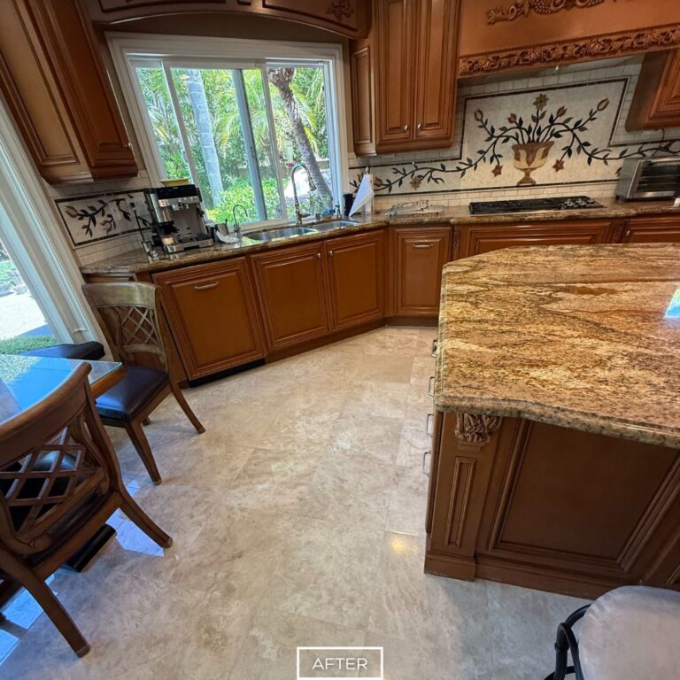 Smooth and glossy travertine flooring near kitchen counters in Beverly Hills after professional stone restoration.