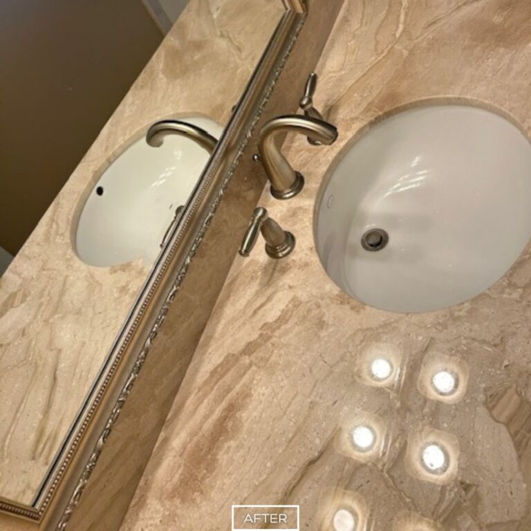 Restored travertine countertop in Walnut bathroom after polishing, with glossy reflective finish highlighting natural stone patterns.