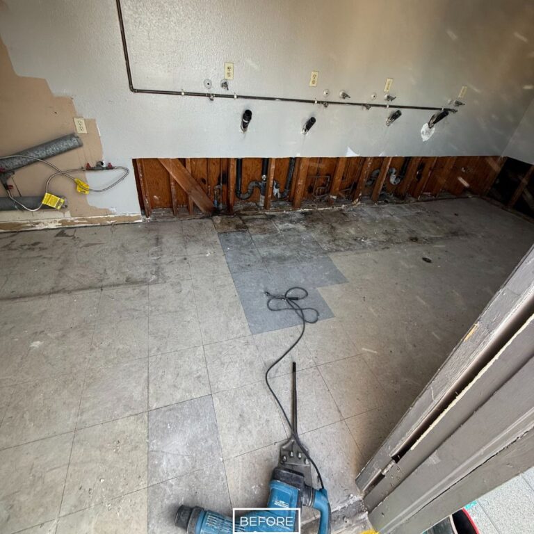 Concrete floor with adhesive stains and leftover tile patches, photographed before grinding and polishing process.
