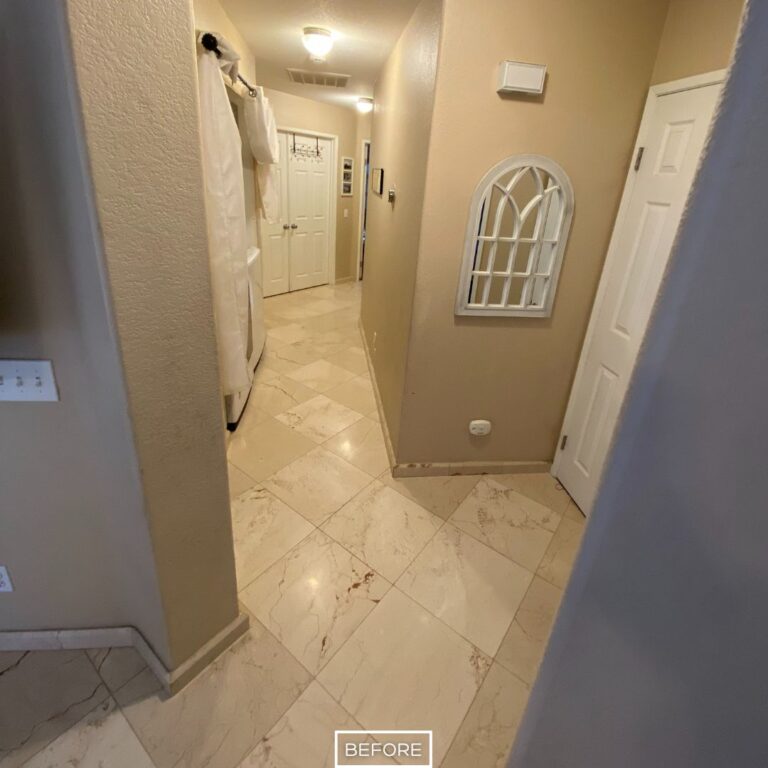Hallway marble floor in Los Angeles home before restoration, with dull and uneven surface under low light.