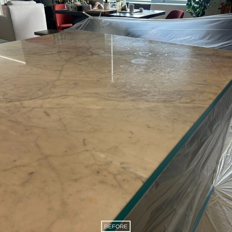 Marble kitchen island countertop in Manhattan Beach with visible water rings, stains, and a dull surface before restoration.