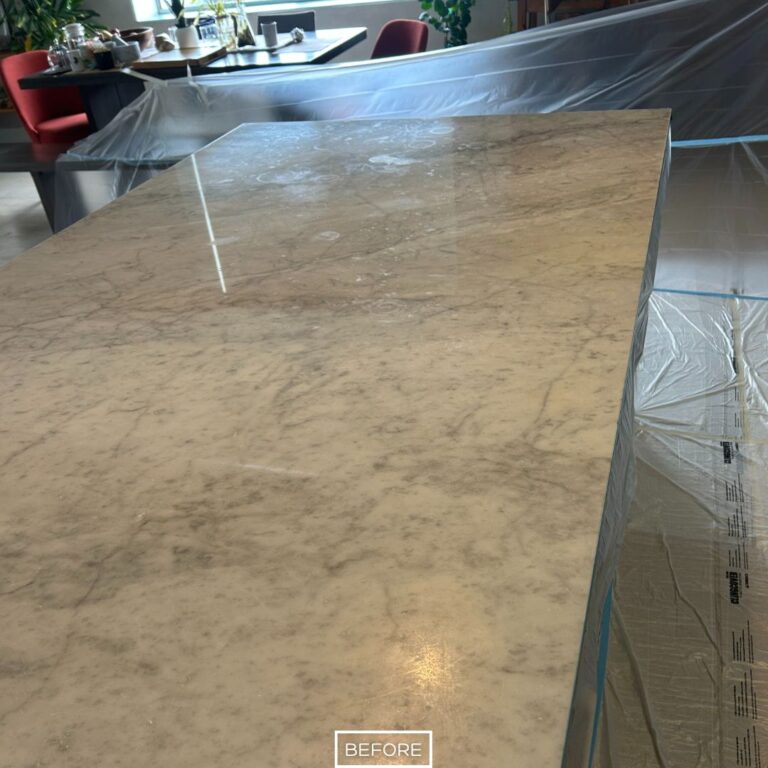 Close-up of a marble countertop showing scratches, etches, and a cloudy finish prior to professional refinishing.