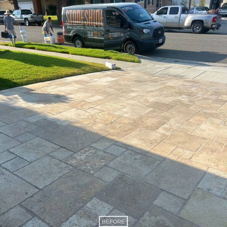 Travertine driveway in Huntington Beach with visible discoloration and buildup before restoration.