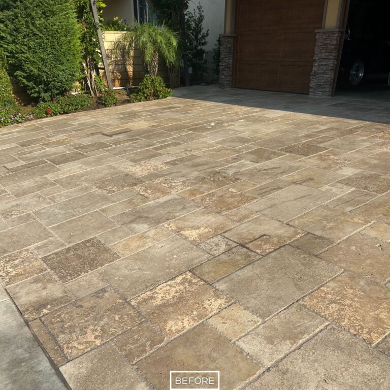 Worn travertine driveway showing dull patches and stains that reduced curb appeal.