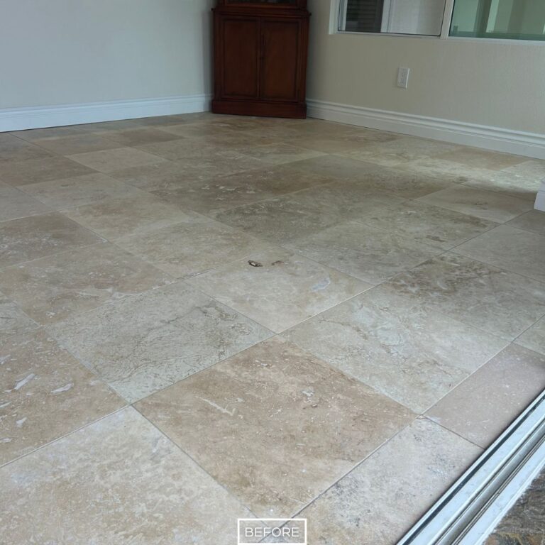 Worn travertine floor in Dana Point with discoloration and dirty grout lines